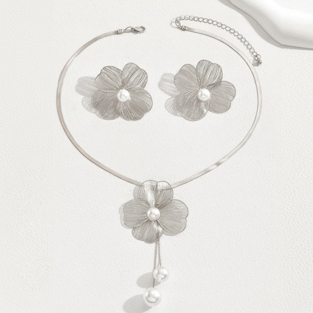 Silver floral necklace and earrings on a white background