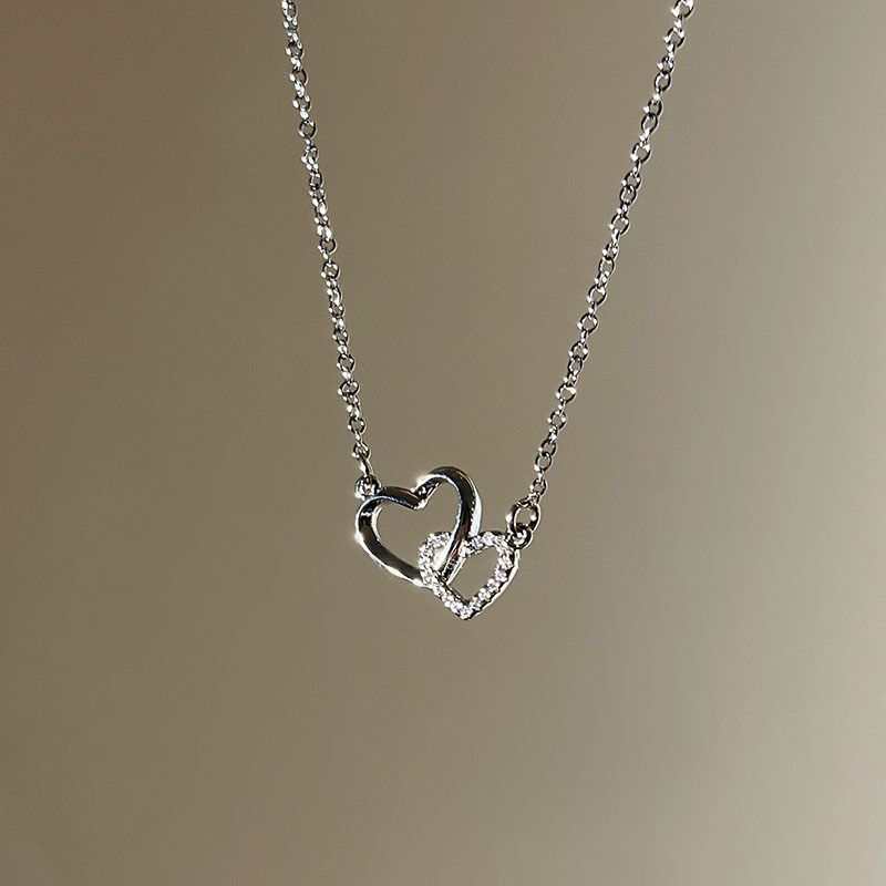 Silver heart-shaped necklace with a blurred background