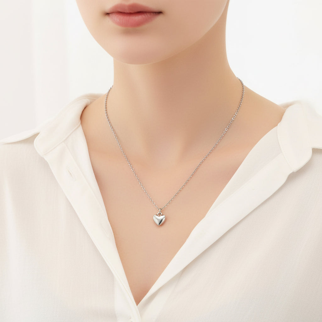 Silver heart-shaped pendant necklace on a white background