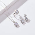 Silver jewelry set with necklace and earrings on a hand against a neutral background
