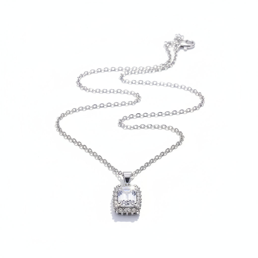 Silver necklace with a heart-shaped pendant on a pink satin background