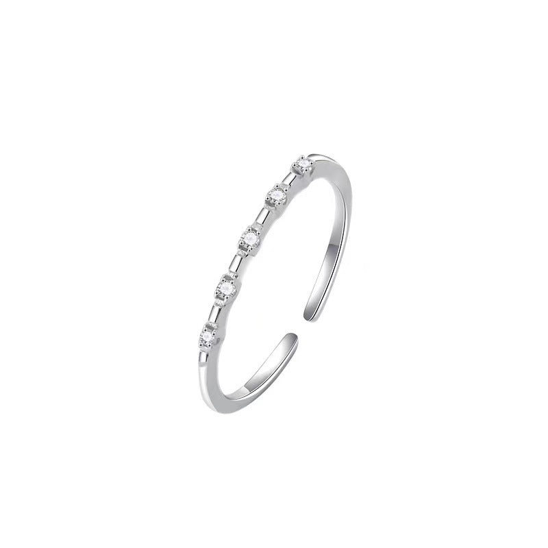 Silver open ring with small diamonds on a white background