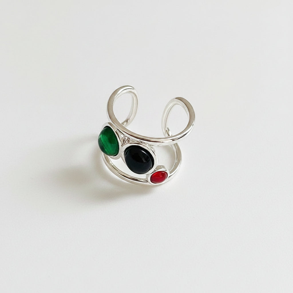 Silver ring with colored stones on a white surface