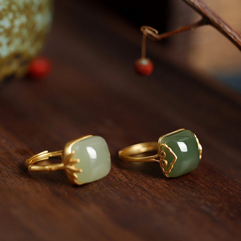 Two gold-rimmed jade rings on a wooden 
