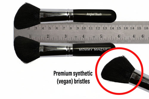 Two makeup brushes with 'Mommy Makeup' branding, one with a ruler for size reference, and text highlighting vegan synthetic bristles.