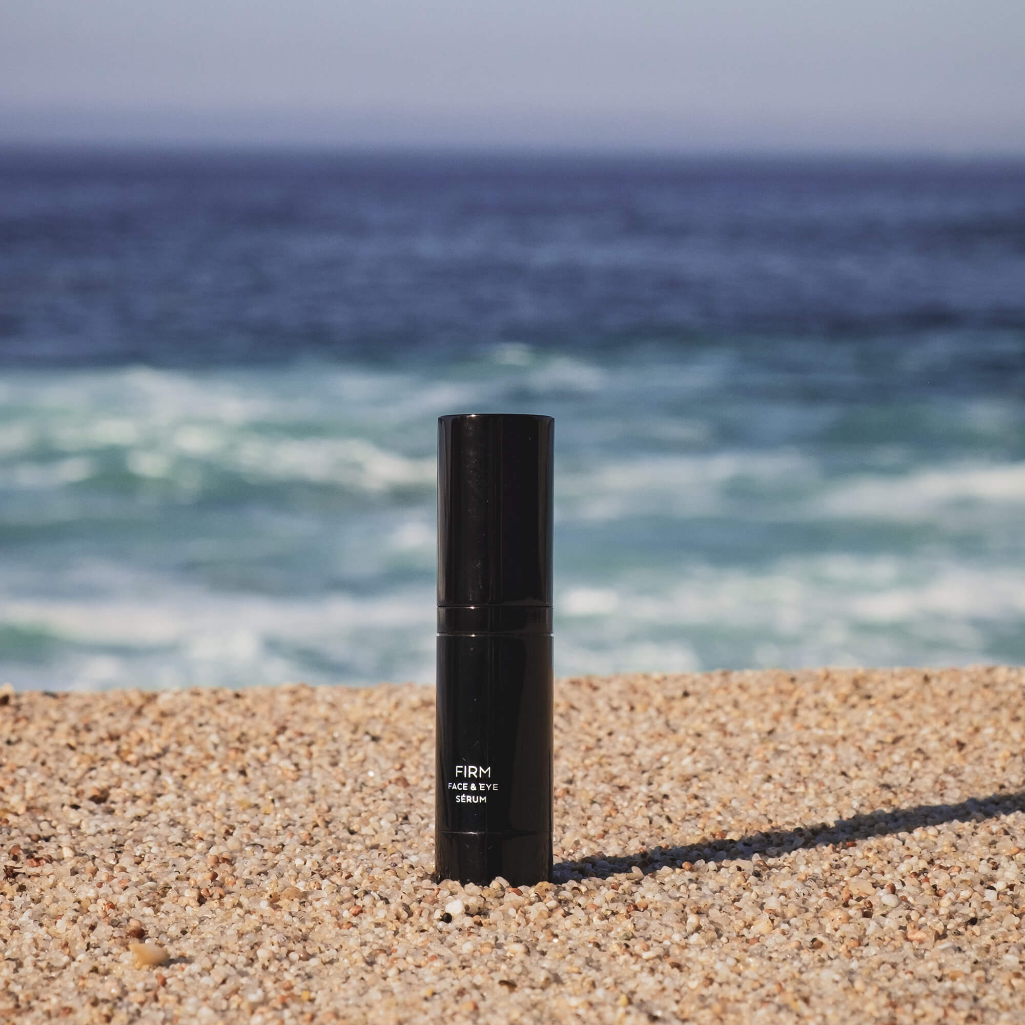 Linda's Look Firm Serum, lifestyle shot of the firming face serum bottle on a neutral surface